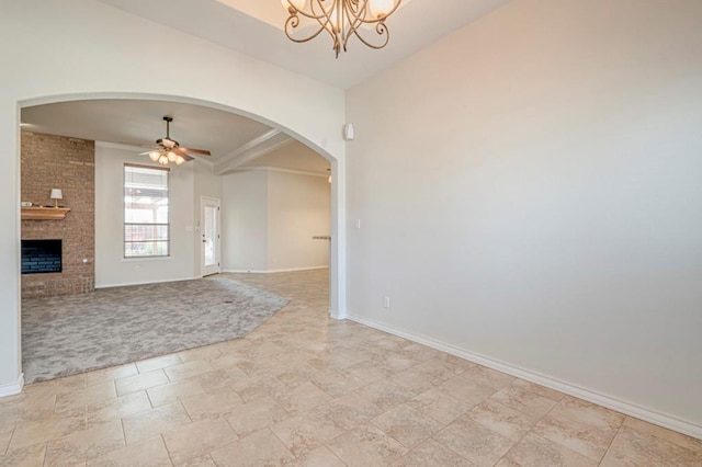 interior space featuring a fireplace, ceiling fan with notable chandelier, and ornamental molding