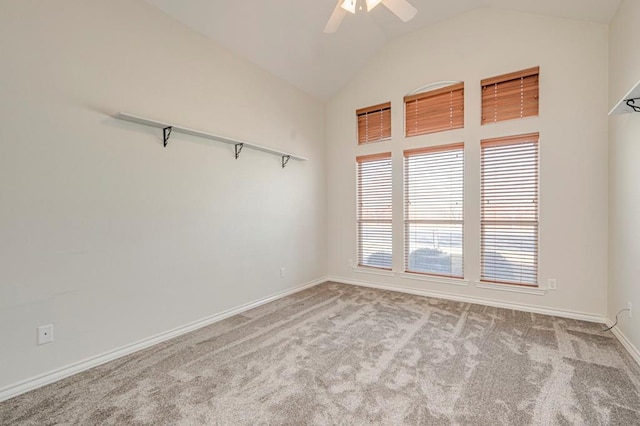 carpeted spare room with ceiling fan and lofted ceiling