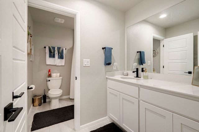 bathroom featuring toilet, baseboards, and vanity