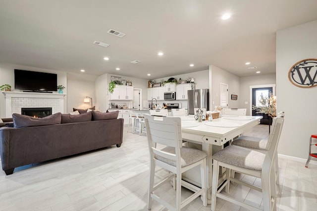 dining area featuring recessed lighting, visible vents, a fireplace, and baseboards