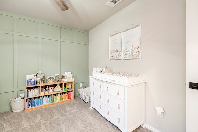 recreation room featuring visible vents, a decorative wall, and light colored carpet