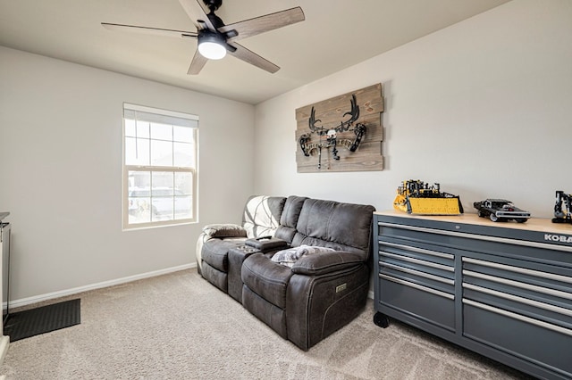 sitting room featuring light carpet, baseboards, and a ceiling fan