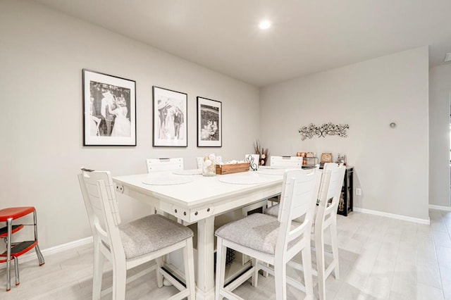 dining area with light wood-style floors and baseboards