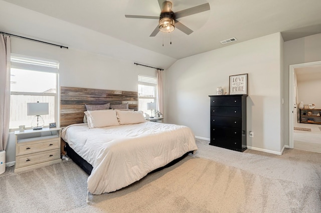 bedroom featuring ceiling fan, light carpet, visible vents, baseboards, and vaulted ceiling