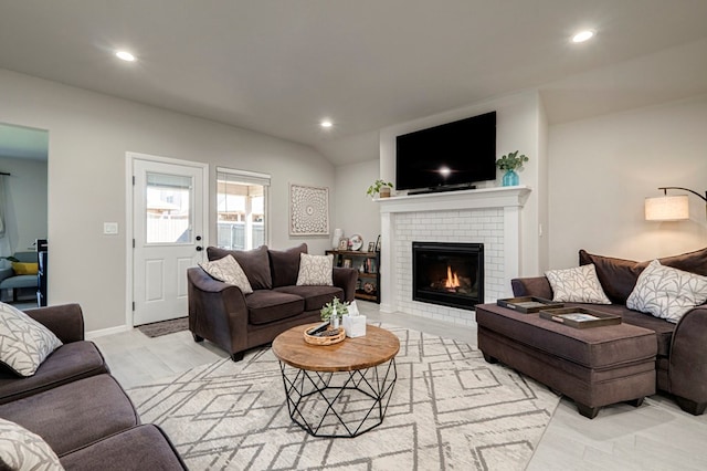 living room with recessed lighting, a brick fireplace, vaulted ceiling, and baseboards