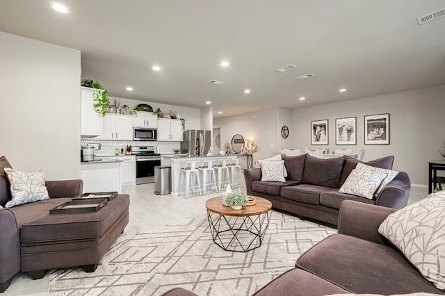 living room featuring recessed lighting and visible vents