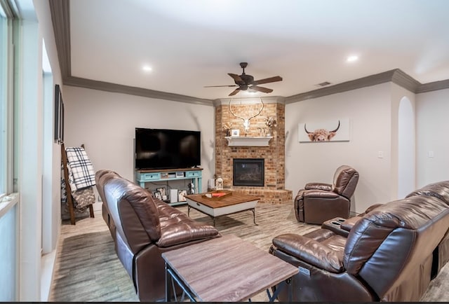 4402 Guadalupe St, Midland, TX 79707 - living room with ceiling fan, crown molding, wood finished floors, a fireplace, and arched walkways
