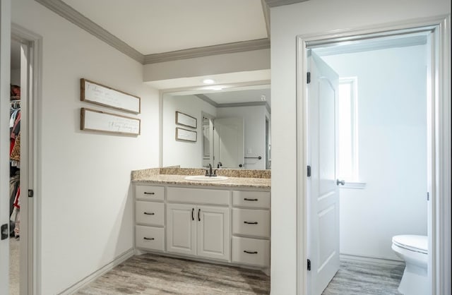 4402 Guadalupe St, Midland, TX 79707 - bathroom with crown molding, vanity, wood finished floors, and a walk in closet