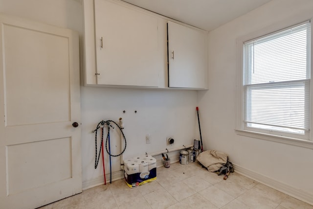 laundry area featuring hookup for a washing machine, light tile patterned floors, and cabinets