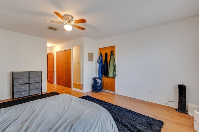 bedroom featuring ceiling fan, light hardwood / wood-style floors, and ensuite bath