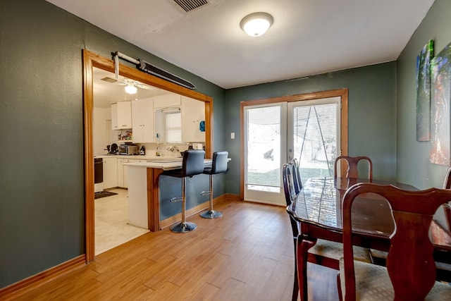 dining space with ceiling fan and light hardwood / wood-style floors