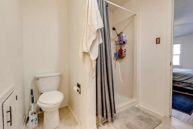 bathroom featuring tile patterned floors, toilet, and walk in shower