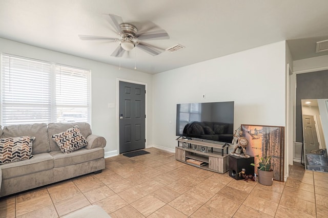 living room featuring baseboards, visible vents, and a ceiling fan