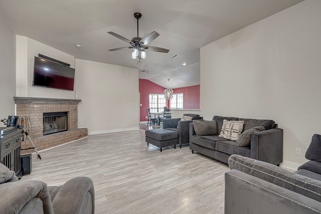 508 E Comiskey, Midland, TX 79706 - living room with light wood-style flooring, a ceiling fan, vaulted ceiling, a brick fireplace, and baseboards