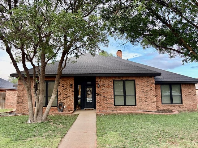 1303 Terra Ct, Midland, TX 79705 - ranch-style house featuring a front yard, a shingled roof, a chimney, and brick siding