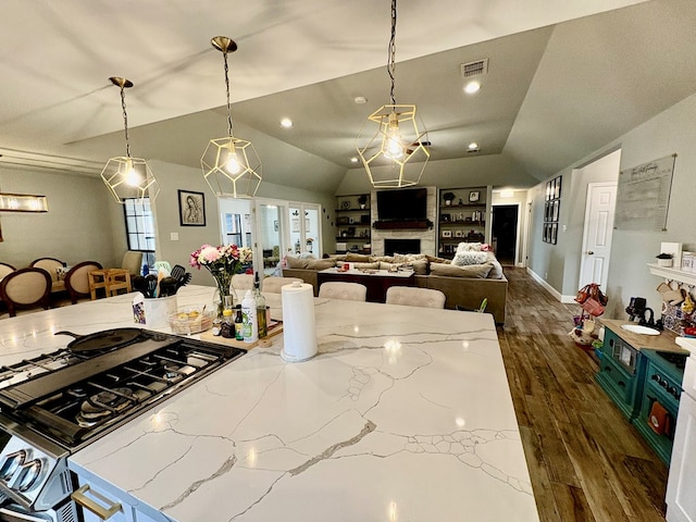 1303 Terra Ct, Midland, TX 79705 - kitchen featuring lofted ceiling, dark wood finished floors, gas stovetop, light stone counters, and hanging light fixtures