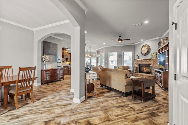 living room with recessed lighting, wood finished floors, visible vents, ornamental molding, and a brick fireplace