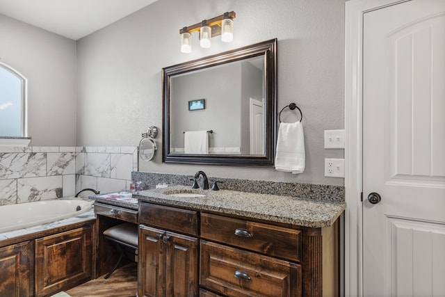 full bathroom with a garden tub and vanity