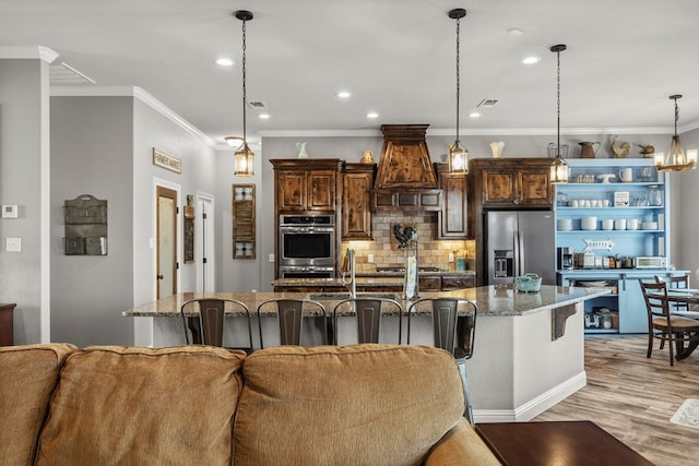 kitchen featuring stainless steel appliances, pendant lighting, a large island, and a kitchen breakfast bar