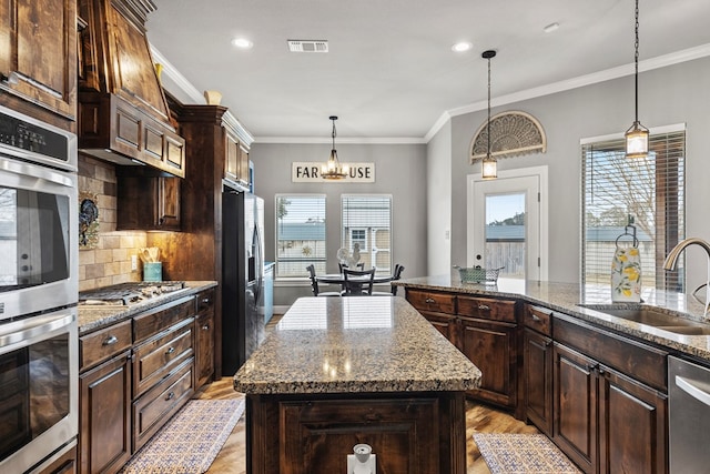 kitchen featuring a sink, dark brown cabinetry, and a center island