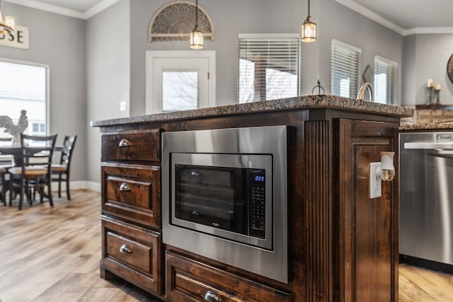 kitchen featuring stainless steel appliances, dark brown cabinetry, and ornamental molding