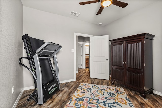 exercise area with dark wood-style floors, baseboards, visible vents, and a ceiling fan