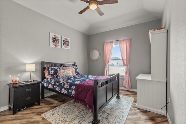 bedroom with lofted ceiling, ceiling fan, baseboards, and wood finished floors