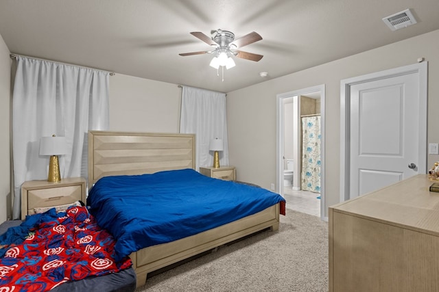 bedroom with ceiling fan, carpet floors, and ensuite bath