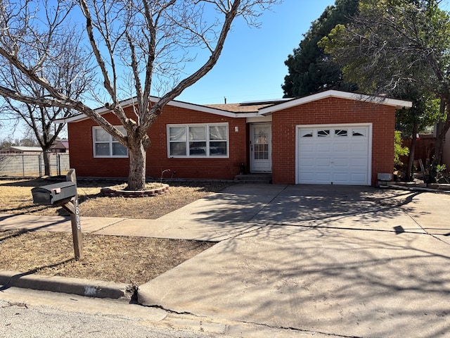 ranch-style home featuring fence, solar panels, concrete driveway, a garage, and brick siding