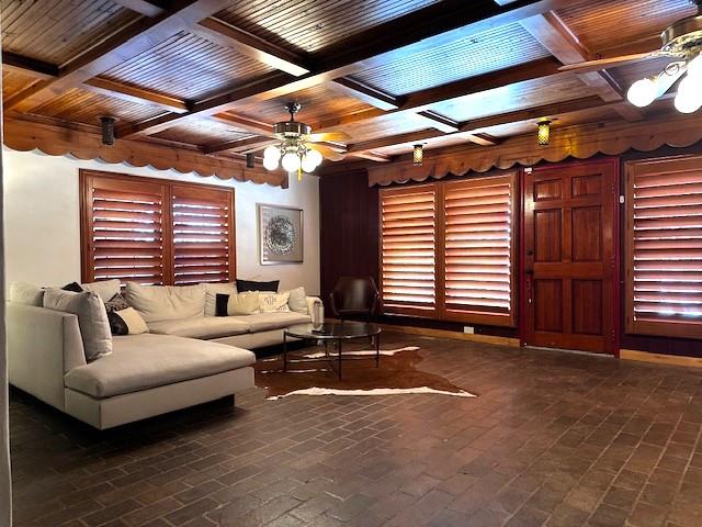 living room with ceiling fan, beam ceiling, and wooden ceiling