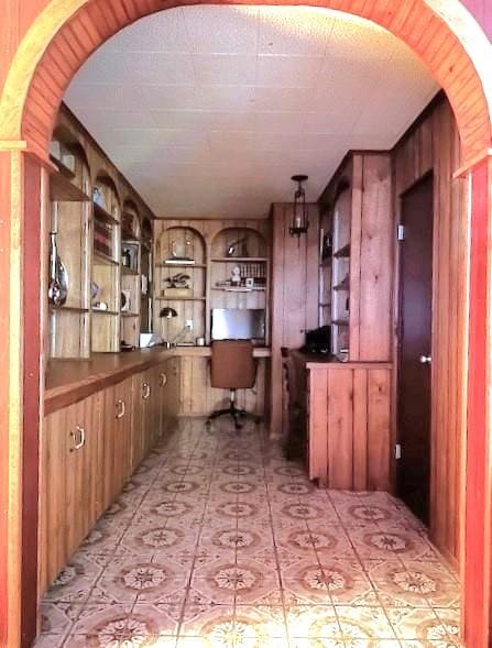 interior space with hanging light fixtures and wooden walls