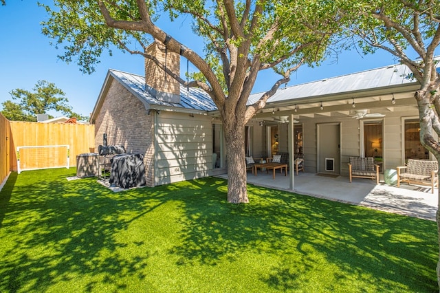 rear view of property featuring a lawn, ceiling fan, and a patio area