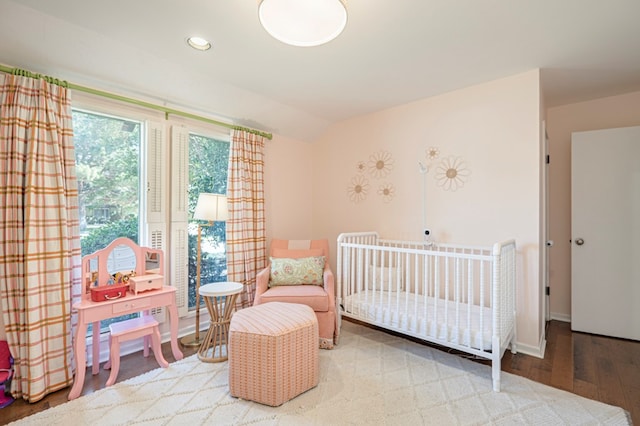 bedroom featuring a crib and wood-type flooring