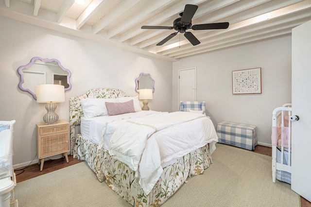 bedroom featuring ceiling fan, hardwood / wood-style floors, and beamed ceiling