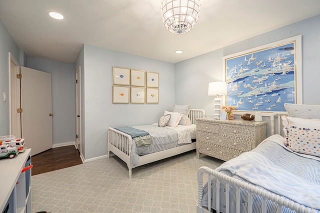 bedroom with light hardwood / wood-style floors and a notable chandelier