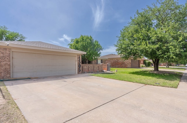 view of front facade featuring brick siding, a front yard, and a garage