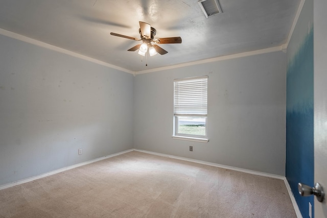 carpeted spare room featuring a ceiling fan, baseboards, and ornamental molding
