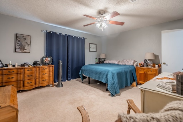 bedroom with light colored carpet, a ceiling fan, and a textured ceiling