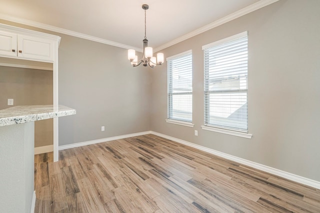 empty room with an inviting chandelier, ornamental molding, and light wood-type flooring