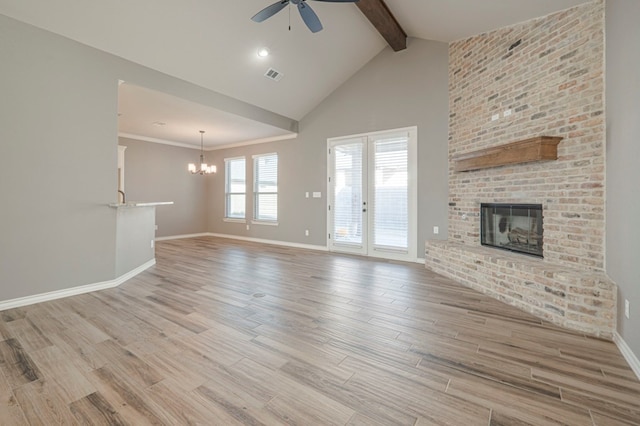 unfurnished living room featuring ceiling fan with notable chandelier, high vaulted ceiling, a fireplace, light hardwood / wood-style floors, and beam ceiling