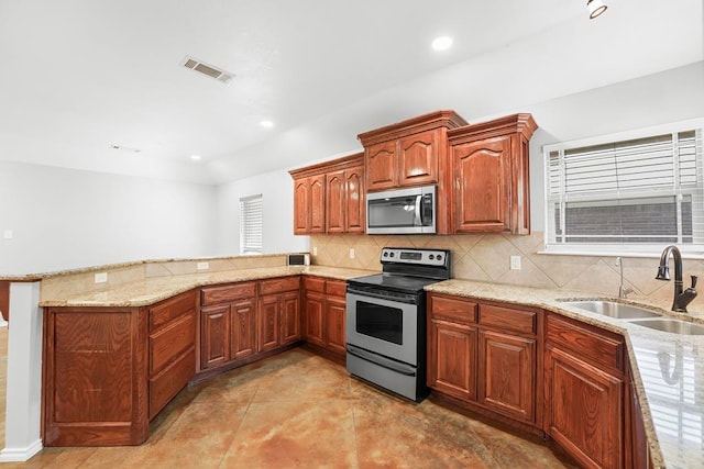 4910 Rio Grande Ave, Midland, TX 79707 - kitchen with stainless steel appliances, a peninsula, light stone counters, decorative backsplash, and recessed lighting