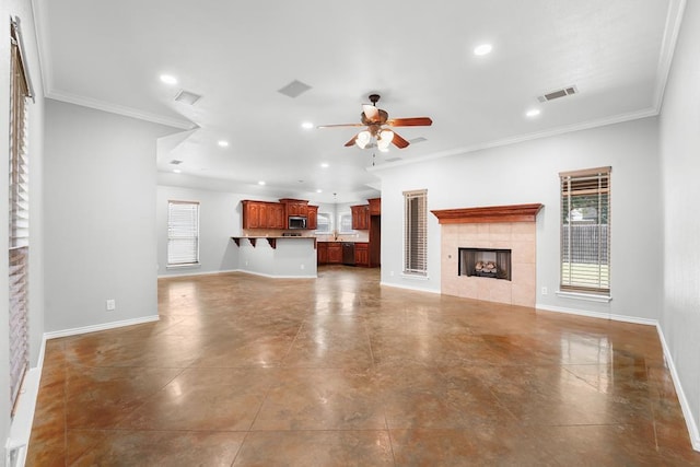 4910 Rio Grande Ave, Midland, TX 79707 - unfurnished living room featuring a ceiling fan, healthy amount of natural light, a fireplace, recessed lighting, and crown molding
