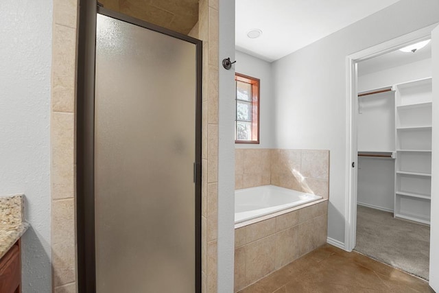 4910 Rio Grande Ave, Midland, TX 79707 - bathroom with a spacious closet, vanity, a shower stall, and a bath