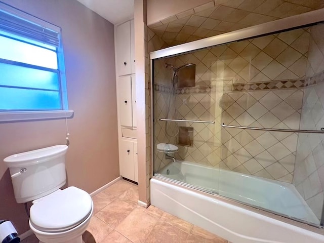 bathroom with bath / shower combo with glass door, tile patterned flooring, and toilet