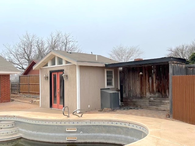 back of property featuring a patio area and an empty pool