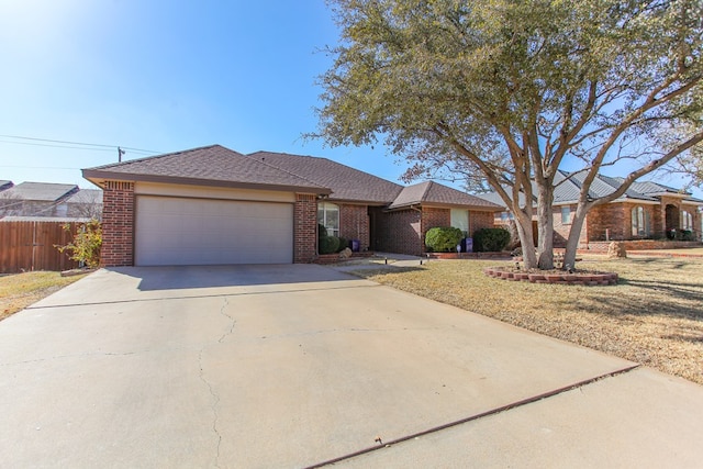 ranch-style house featuring an attached garage, fence, concrete driveway, and brick siding