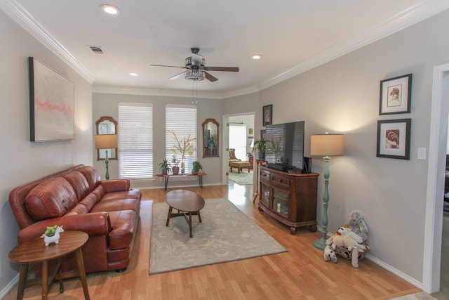 living area with light wood-type flooring, baseboards, visible vents, and crown molding