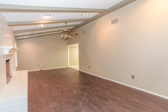 unfurnished living room with a brick fireplace, hardwood / wood-style flooring, ceiling fan, and vaulted ceiling with beams