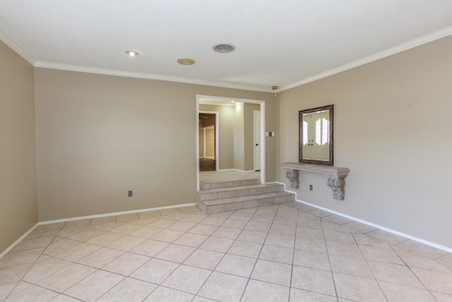 tiled empty room featuring ornamental molding and a textured ceiling