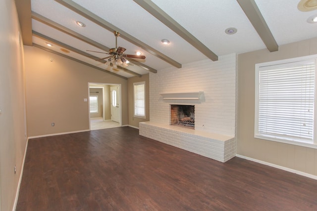 unfurnished living room featuring a brick fireplace, dark wood-type flooring, ceiling fan, and vaulted ceiling with beams